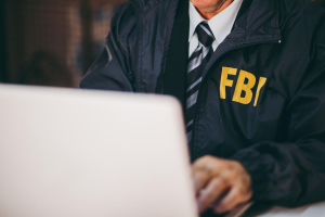 FBI agent working on a laptop during an investigation into AI trade secret theft and economic espionage.
