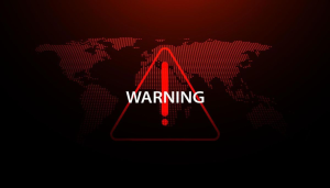 Red warning symbol over a world map representing a global cybersecurity alert related to an active Remcos RAT malware campaign.
