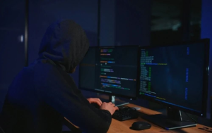 Hacker operating multiple computer screens symbolizing active exploitation of an unpatched WinRAR vulnerability