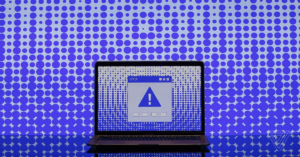 Laptop showing security warning representing malware infection caused by a compromised development package.