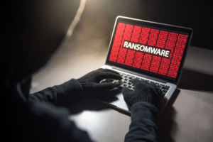 Laptop screen displaying ransomware message with encrypted files during cyberattack used for extortion and financial damage