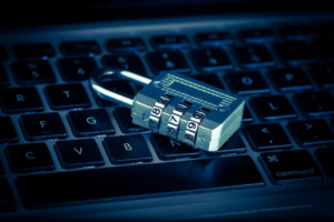 Padlock placed on laptop keyboard symbolizing compromised Microsoft account security in phishing attack