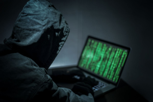 Hacker using laptop in dark environment symbolizing unauthorized access to Bitcoin Depot internal systems